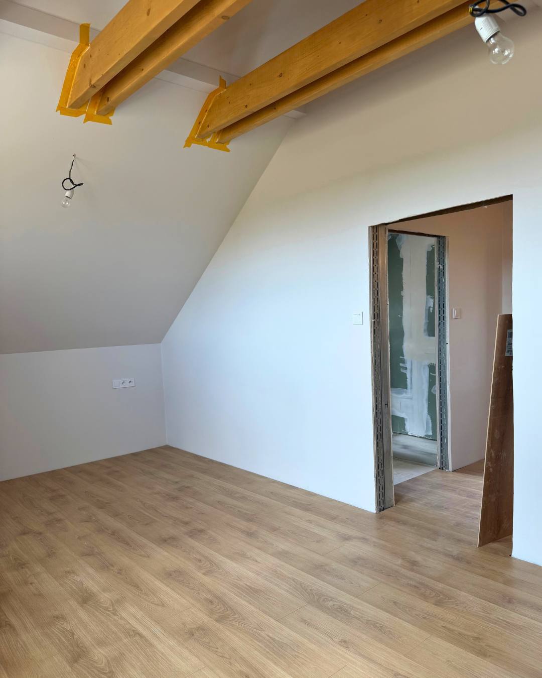 Podkrovná miestnosť s vymaľovanými šikminami a novou podlahou